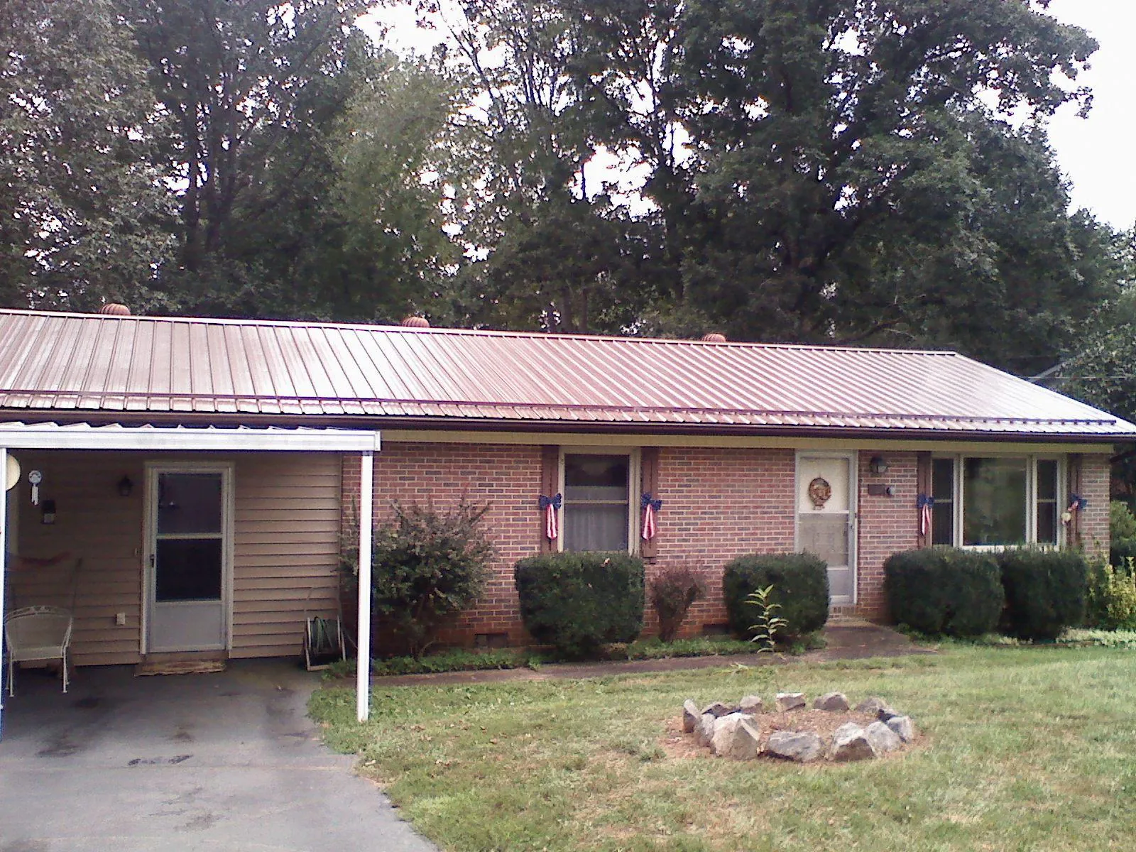 Bronze metal roof and carport on a brick ranch home — Roof Repair work by our crew in Hookerton